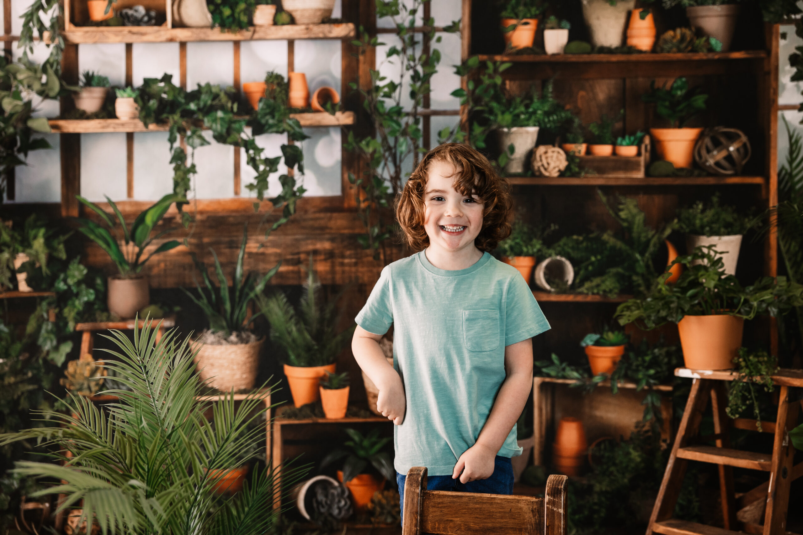 little boy stands in greenhouse