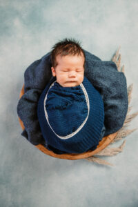 baby wrapped in blue in a bowl
